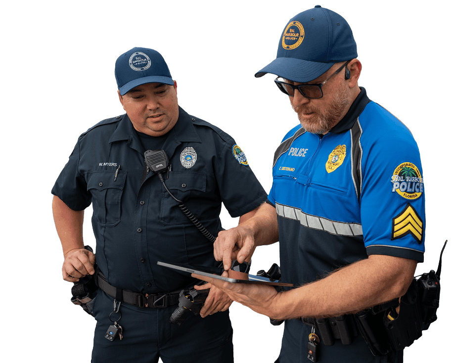 Two policeman standing and looking at a tablet.